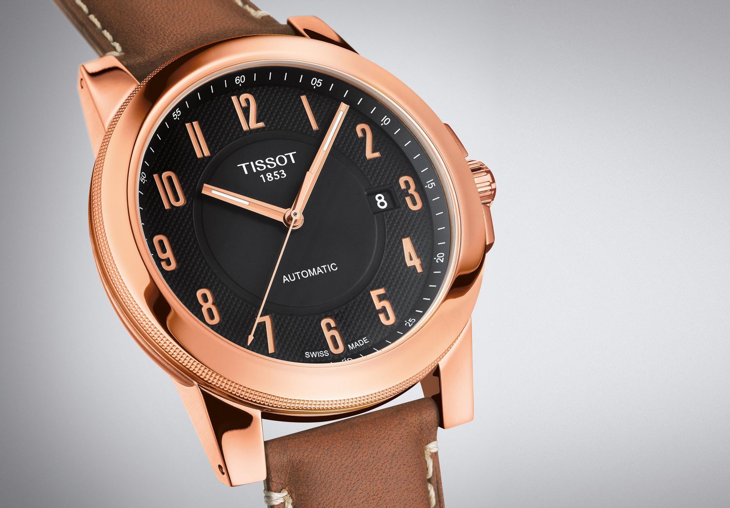 A Tissot Heritage Navigator Automatic with rose gold case, black dial, and brown leather strap