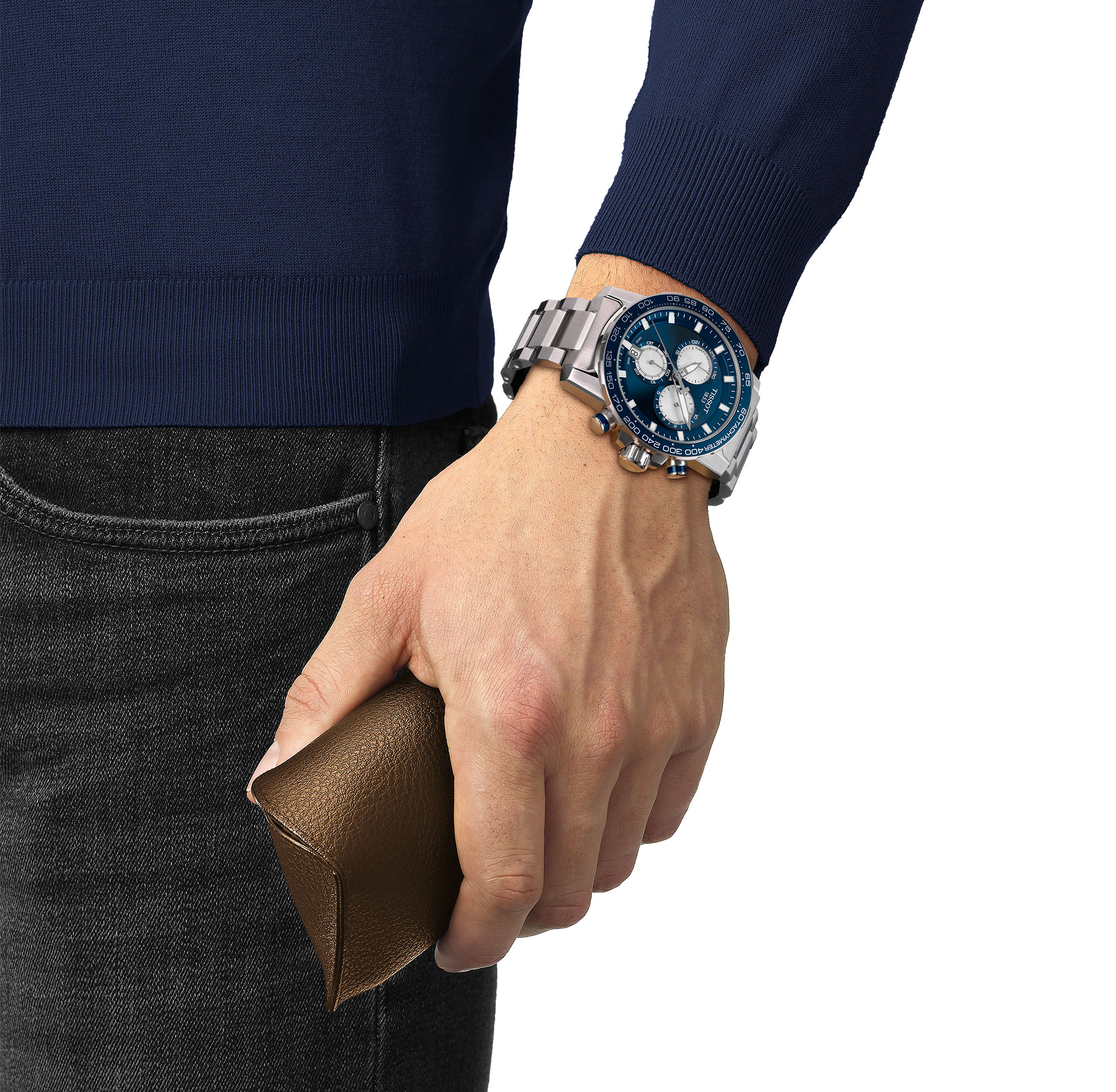 A Tissot Supersport Chrono with a silver stainless steel bracelet, dark blue dial, and three silver-colored chronograph subdials. The watch features a tachymeter scale on the bezel and a date window at 6 o’clock.