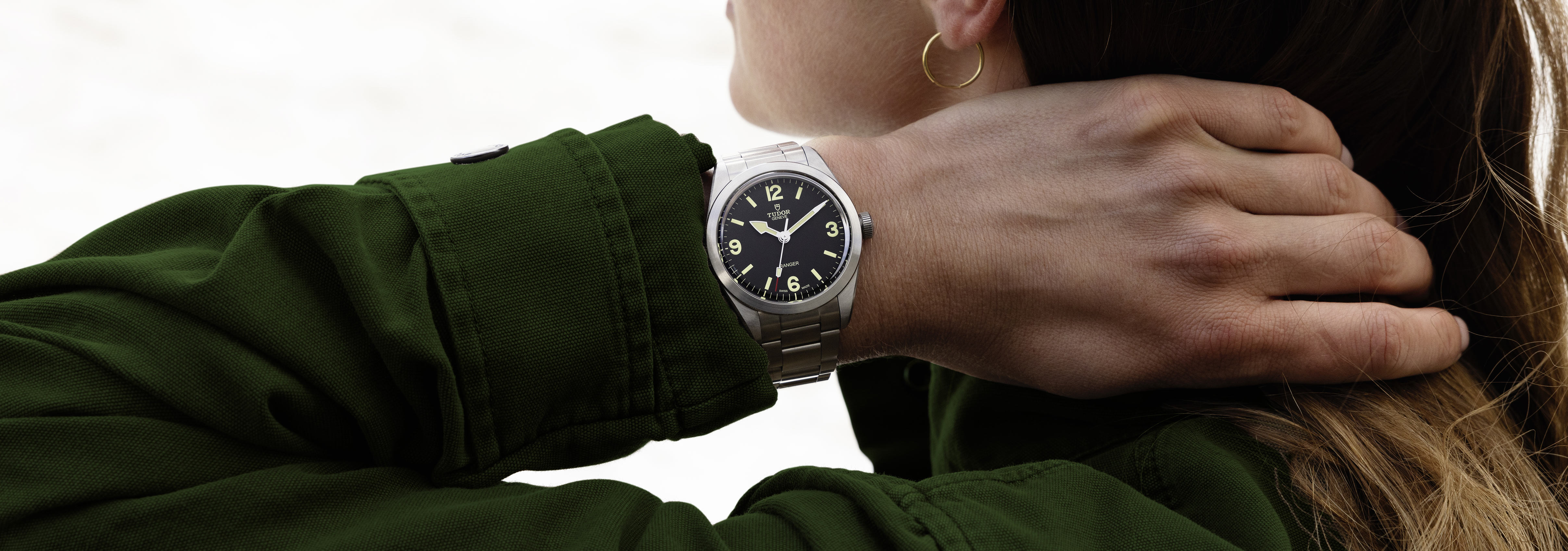 Nærbillede af Tudor Ranger-uret med sort urskive, fremhævet med markante timemarkeringer og et urkasse i rustfrit stål med en poleret sølvfinish. Uret kombinerer robust funktionalitet med tidløs elegance og fremviser Tudors arv inden for holdbart og stilfuldt design.