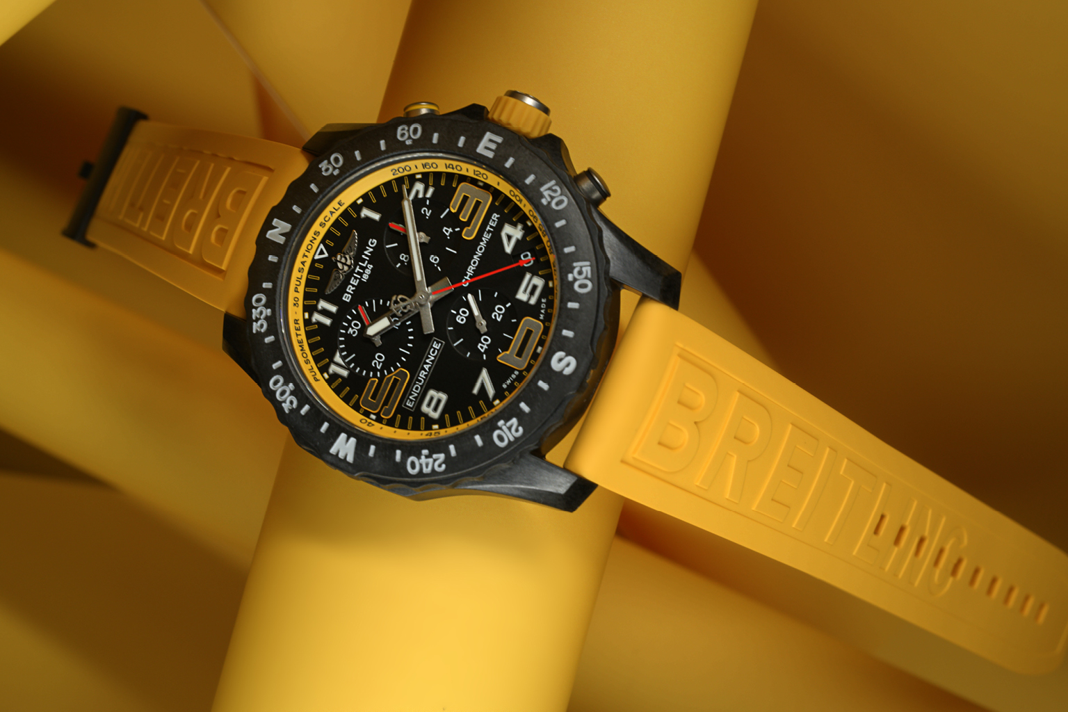 A Breitling “Professional Endurance Pro” with a yellow rubber strap and black dial on a yellow background.
