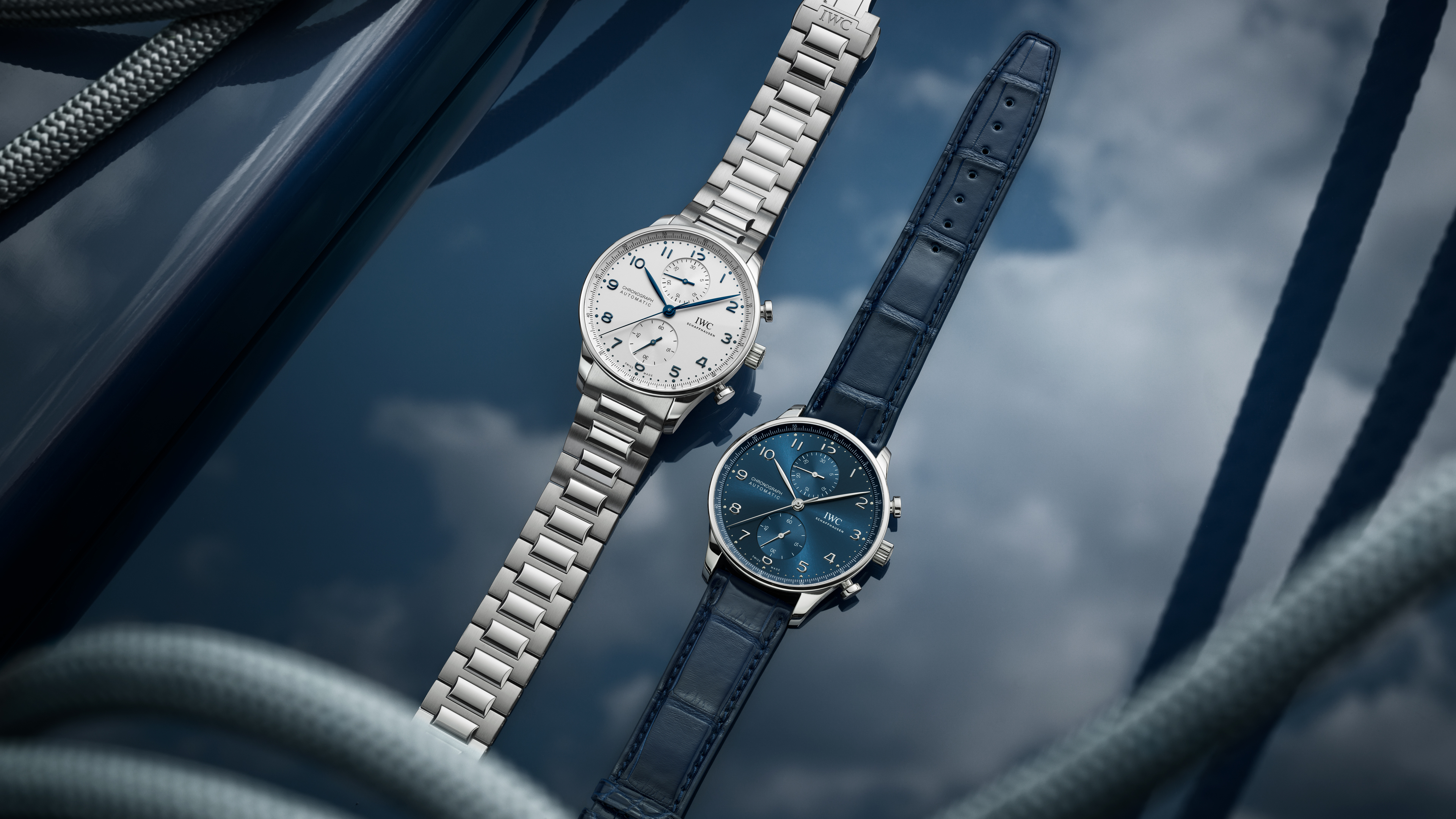 Two IWC Portugieser automatic watches: one with silver dial and stainless steel bracelet, the other with blue dial and leather strap