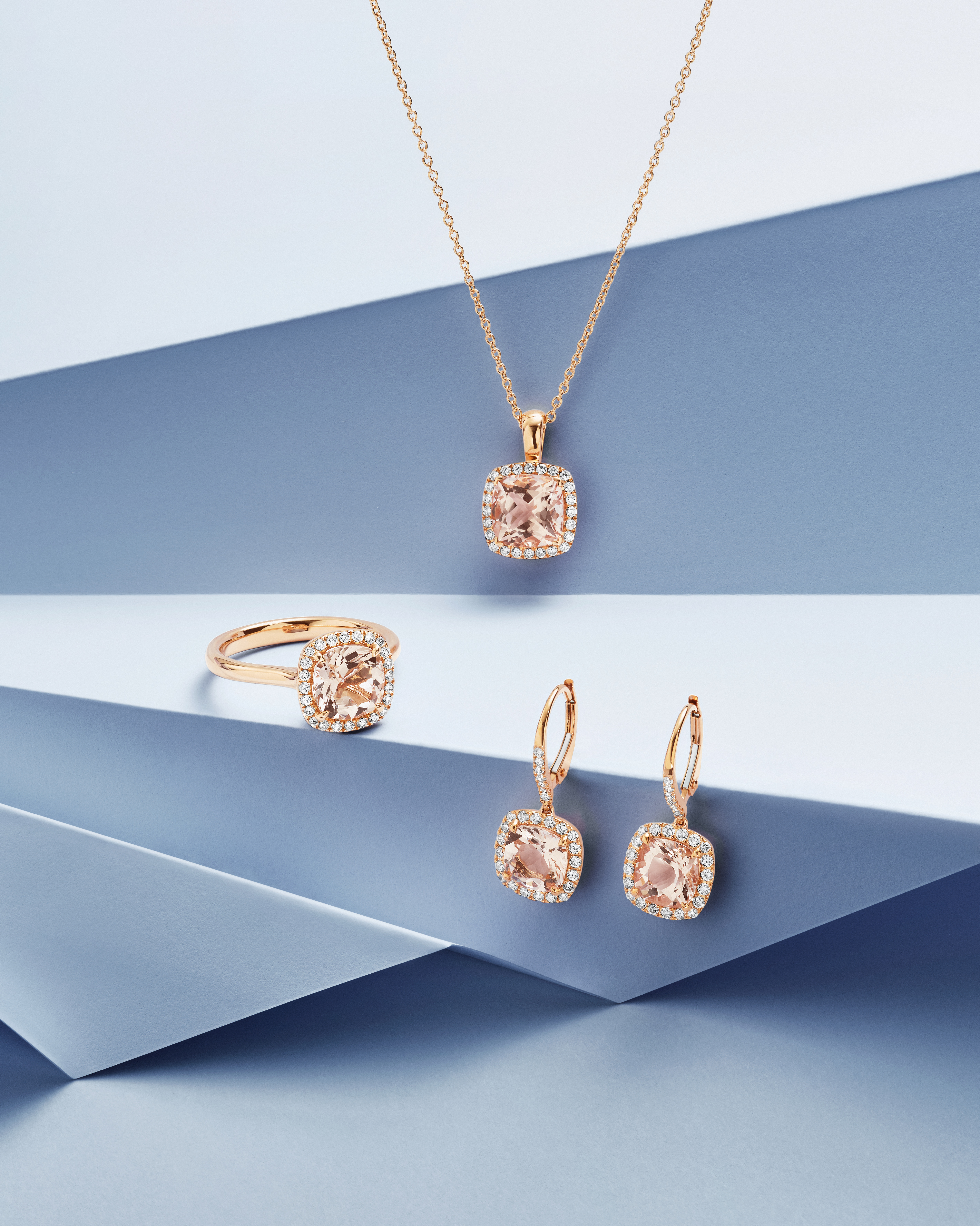 Rose gold jewelry set with cushion-cut morganite gemstones surrounded by diamonds, including a necklace, ring, and earrings.