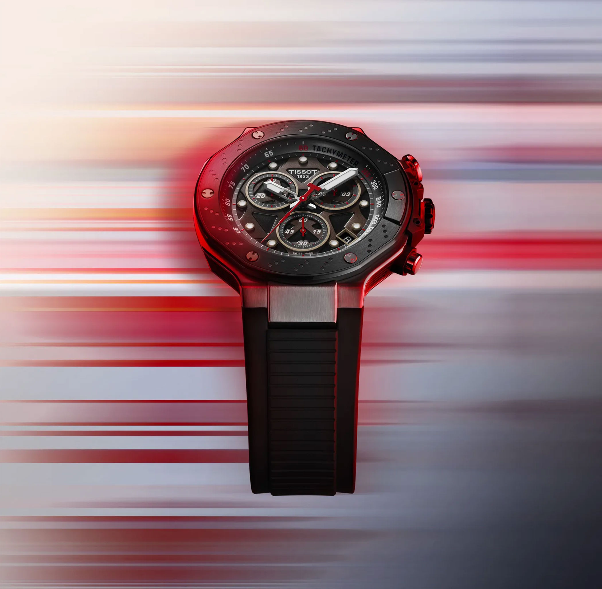 A Tissot T-Race with black case, red accents, and three chronograph subdials on a blurred background.