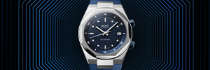 An Ocean Star by Mido with a stainless steel bracelet, a fluted bezel, and a dark dial is lying on a watery surface.