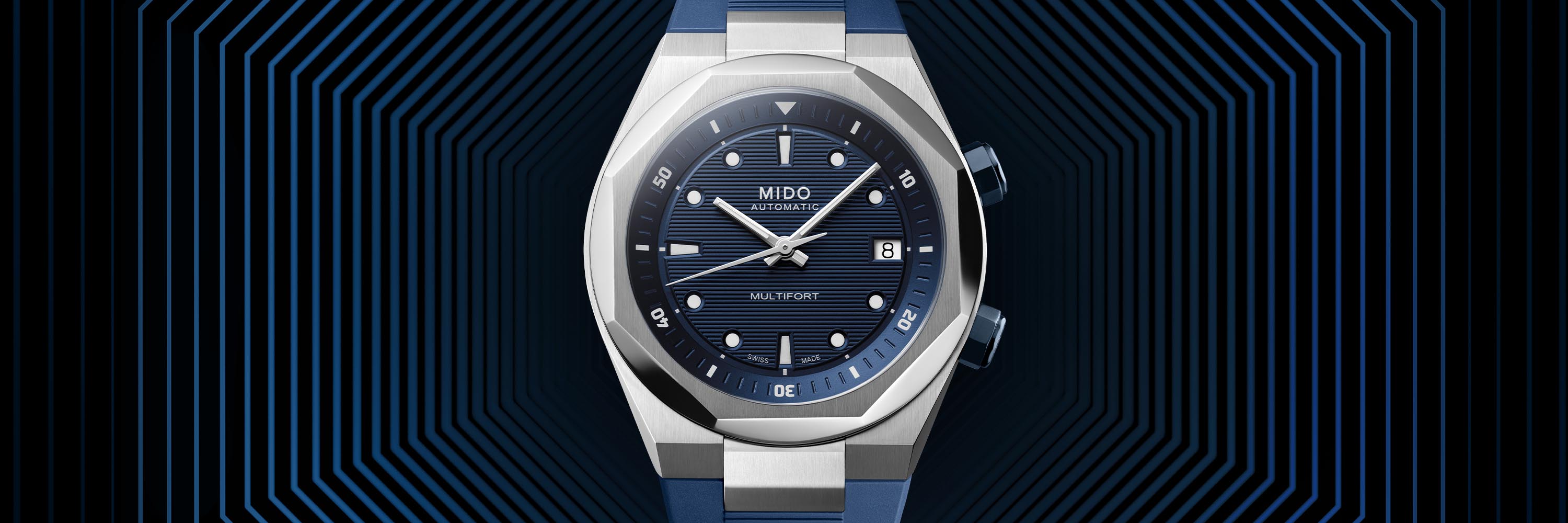  Une Ocean Star de Mido avec un bracelet en acier inoxydable, une lunette cannelée et un cadran sombre repose sur un fond aqueux.