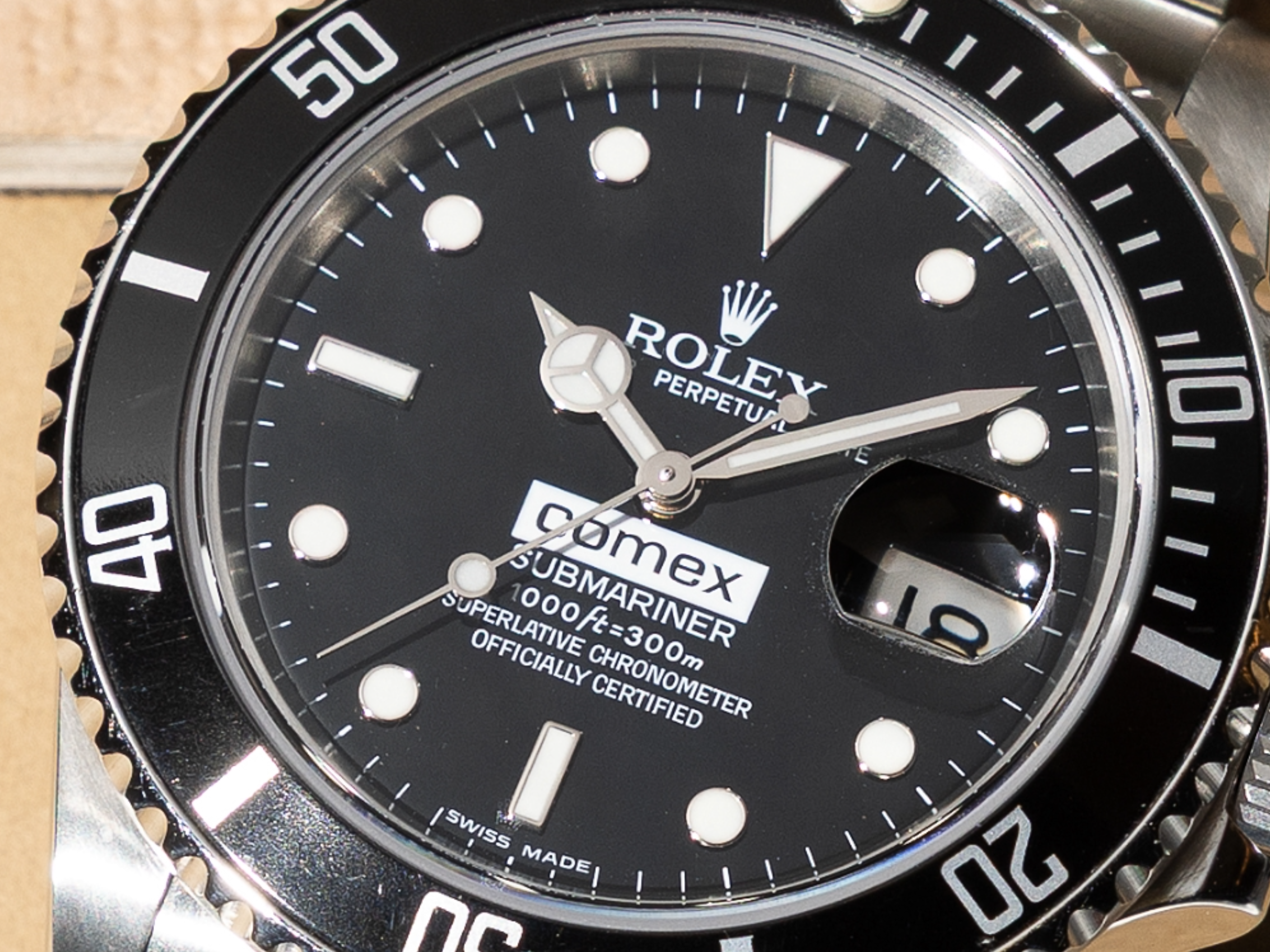 Gros plan sur le cadran noir d'une montre Rolex Submariner avec le logo « comex » et l'affichage de la date.