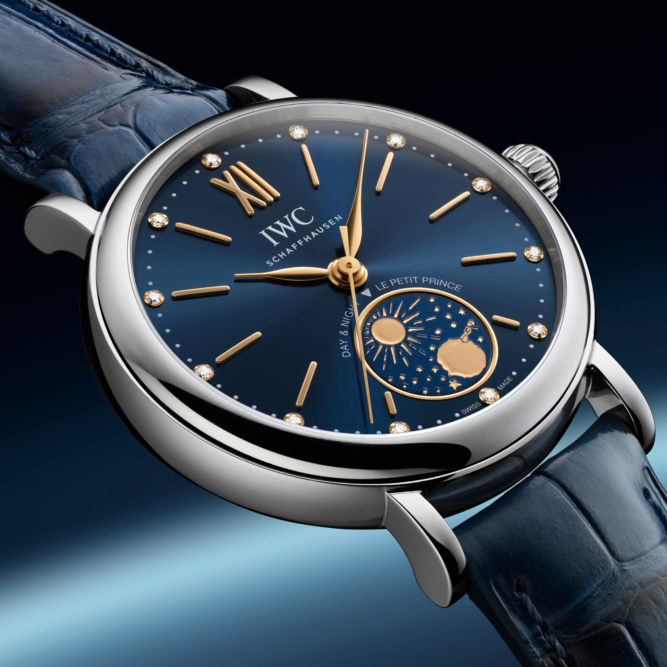 A silver IWC Schaffhausen watch with a blue face, gold hands, diamond hour markers, and a day/night indicator.