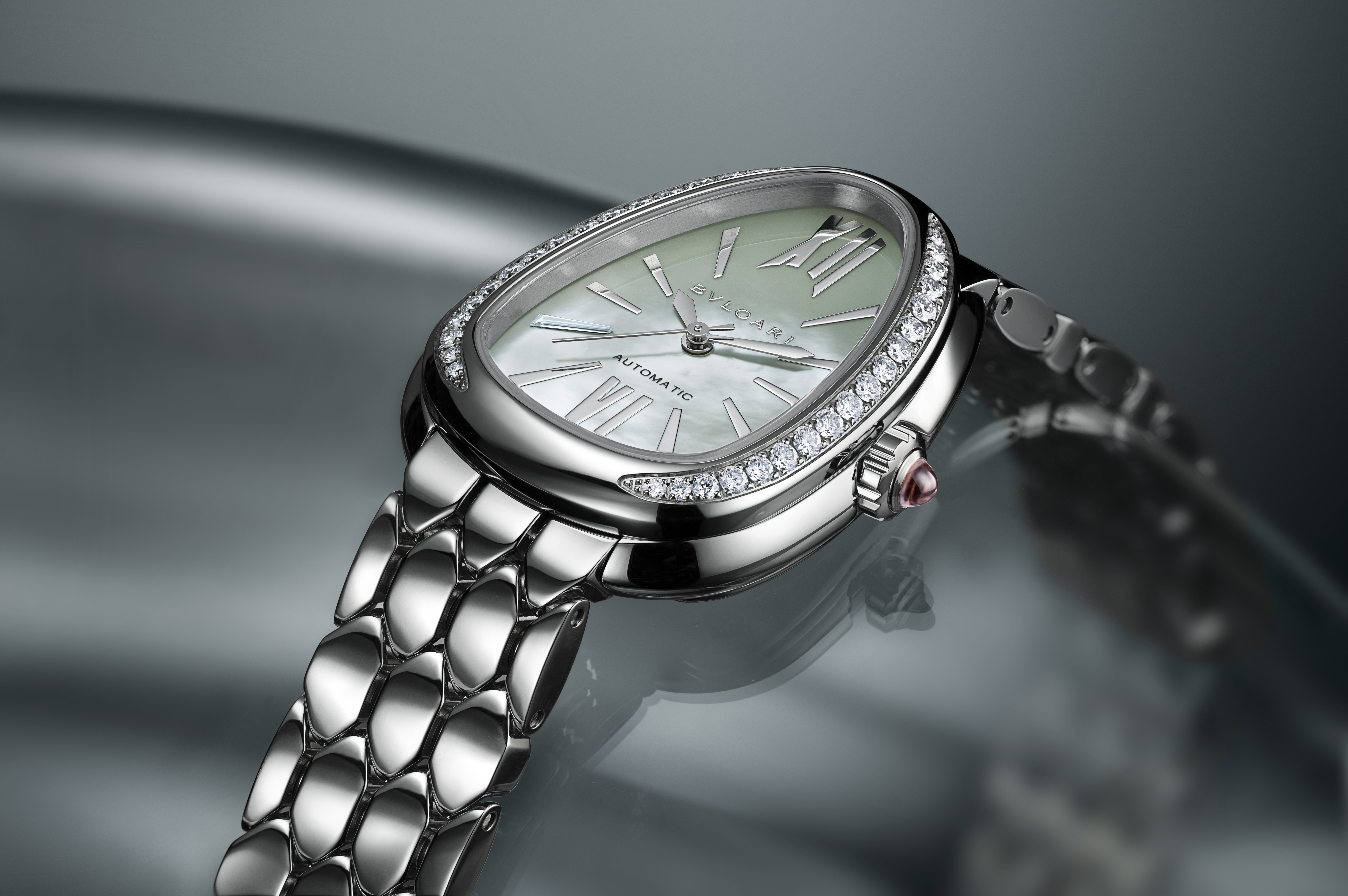 Silberne ovale Uhr mit Perlmuttzifferblatt, Diamantlünette und schuppenförmigem Armband.