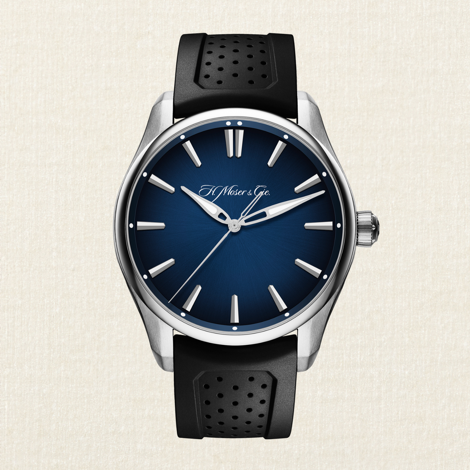 A silver watch with a deep blue face, silver hands, and a black perforated rubber strap.