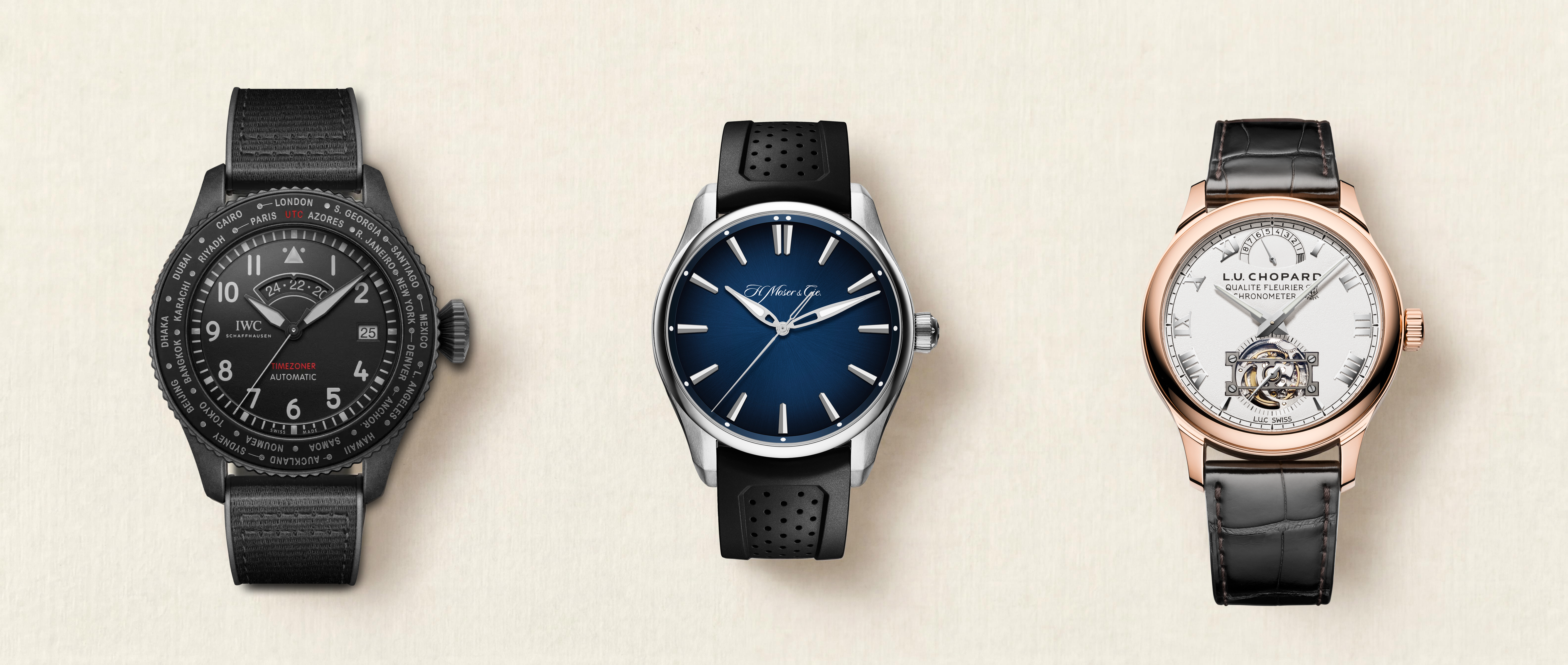 Three luxury watches: a black pilot's watch, a silver watch with a blue face, and a rose gold watch with an exposed mechanism.