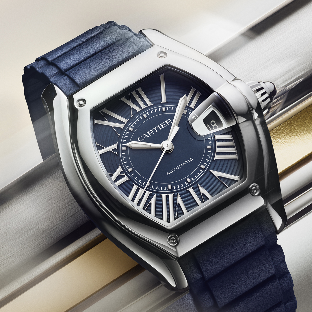A Cartier Roadster watch with a blue dial, silver case, and blue strap.