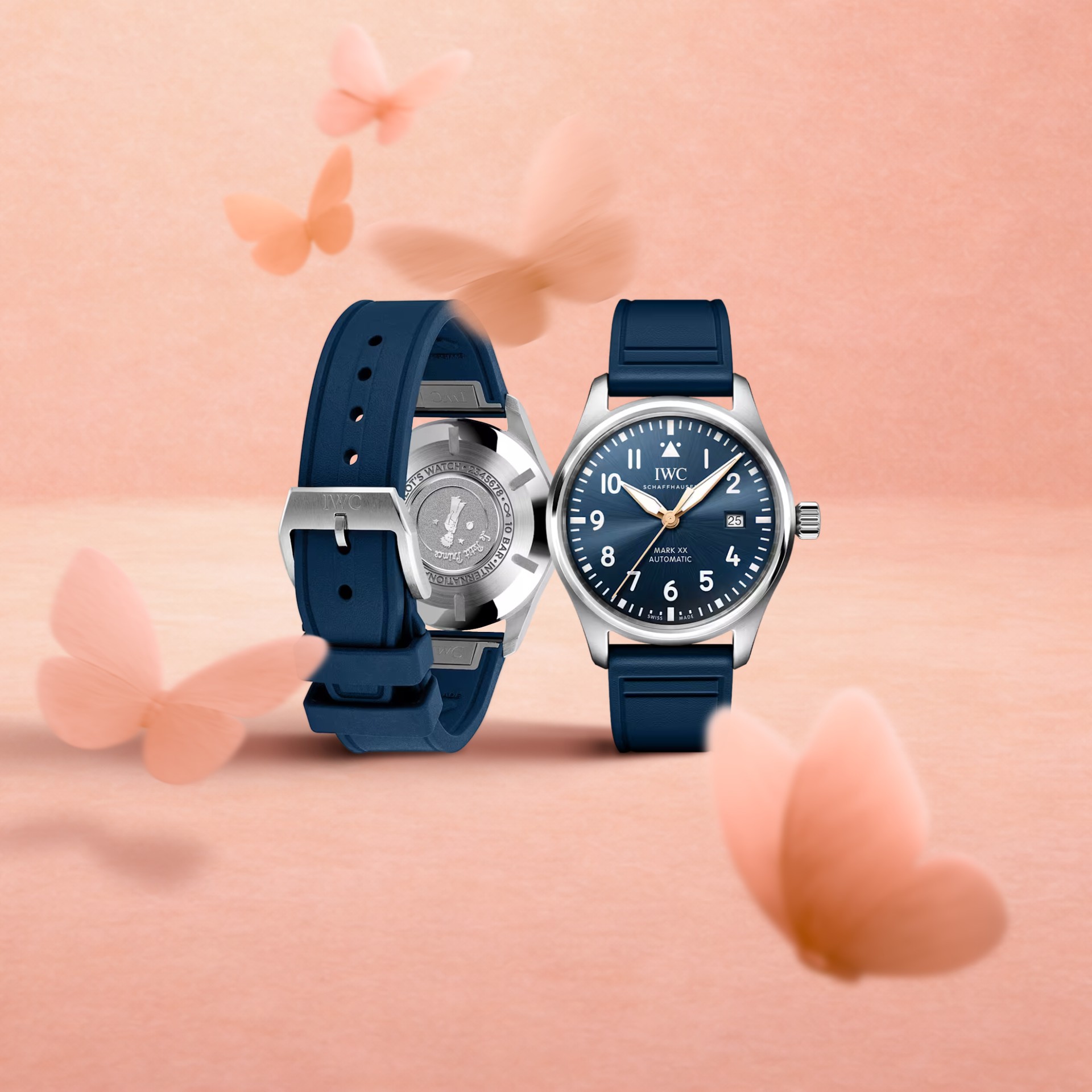 Two IWC Pilot's Watch Automatic 36 watches with blue rubber straps and dials, surrounded by pink butterfly cutouts.