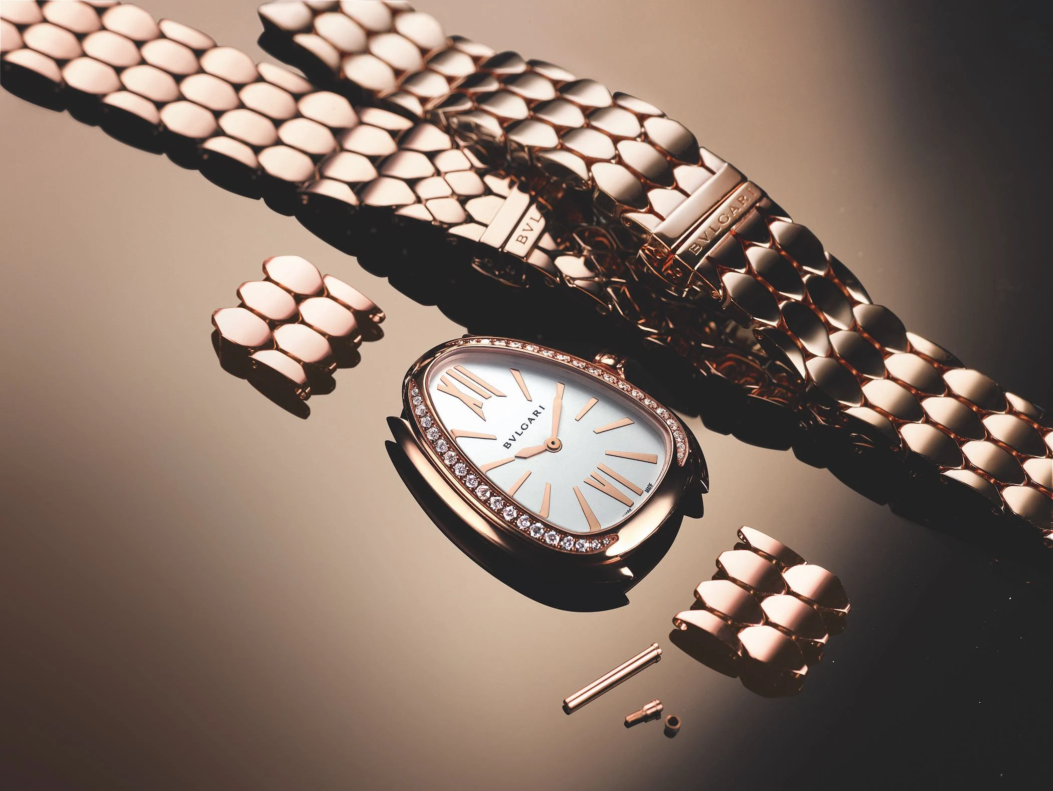 Eine zerlegte Bulgari Serpenti Uhr aus Roségold mit diamantbesetzter Lünette und weißem Zifferblatt.
