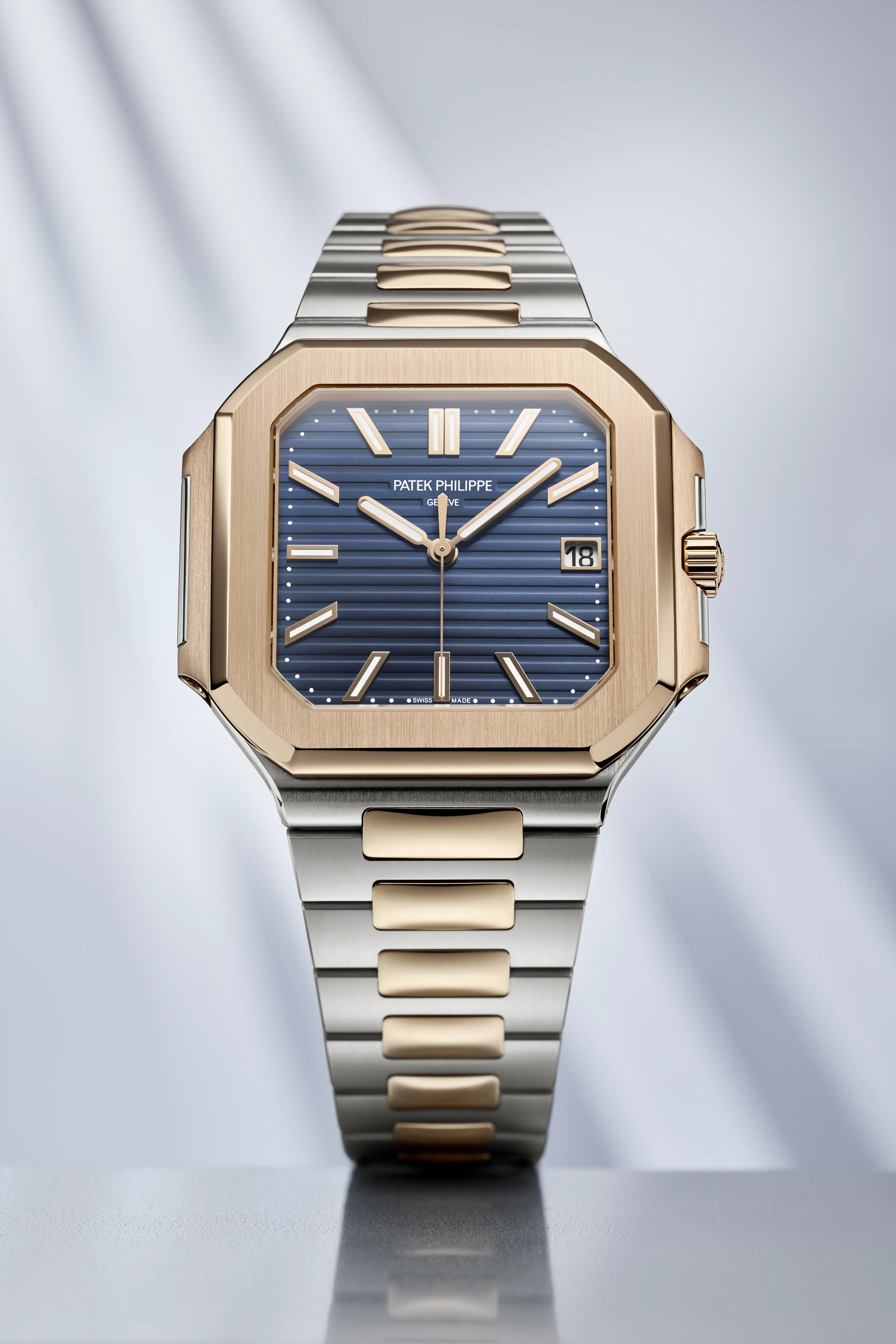 A Patek Philippe watch with a blue dial, rose gold octagonal bezel, and two-tone rose gold and steel bracelet.