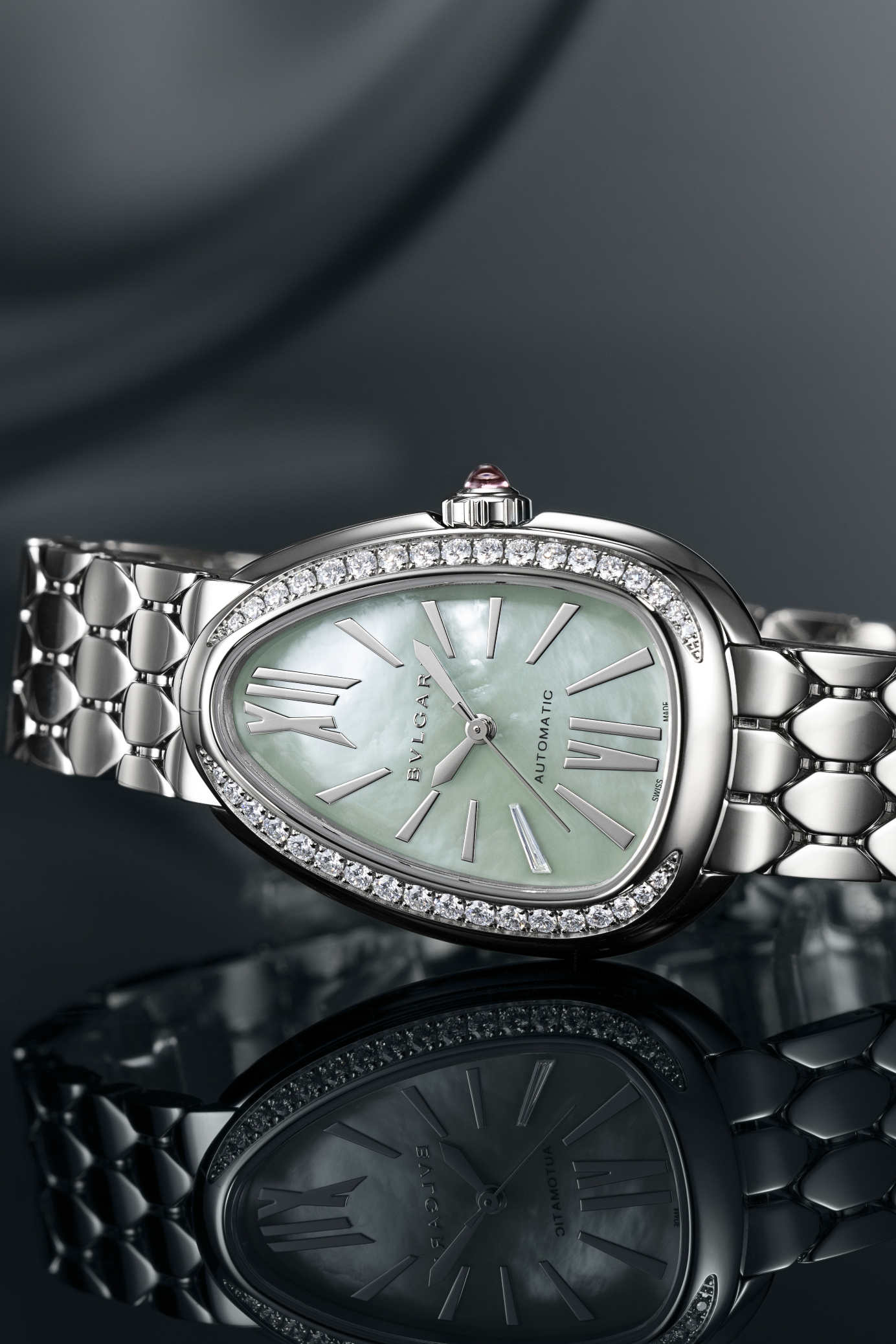 Une montre Bulgari Serpenti en argent avec un cadran en nacre vert clair, une lunette sertie de diamants et un bracelet en argent.
