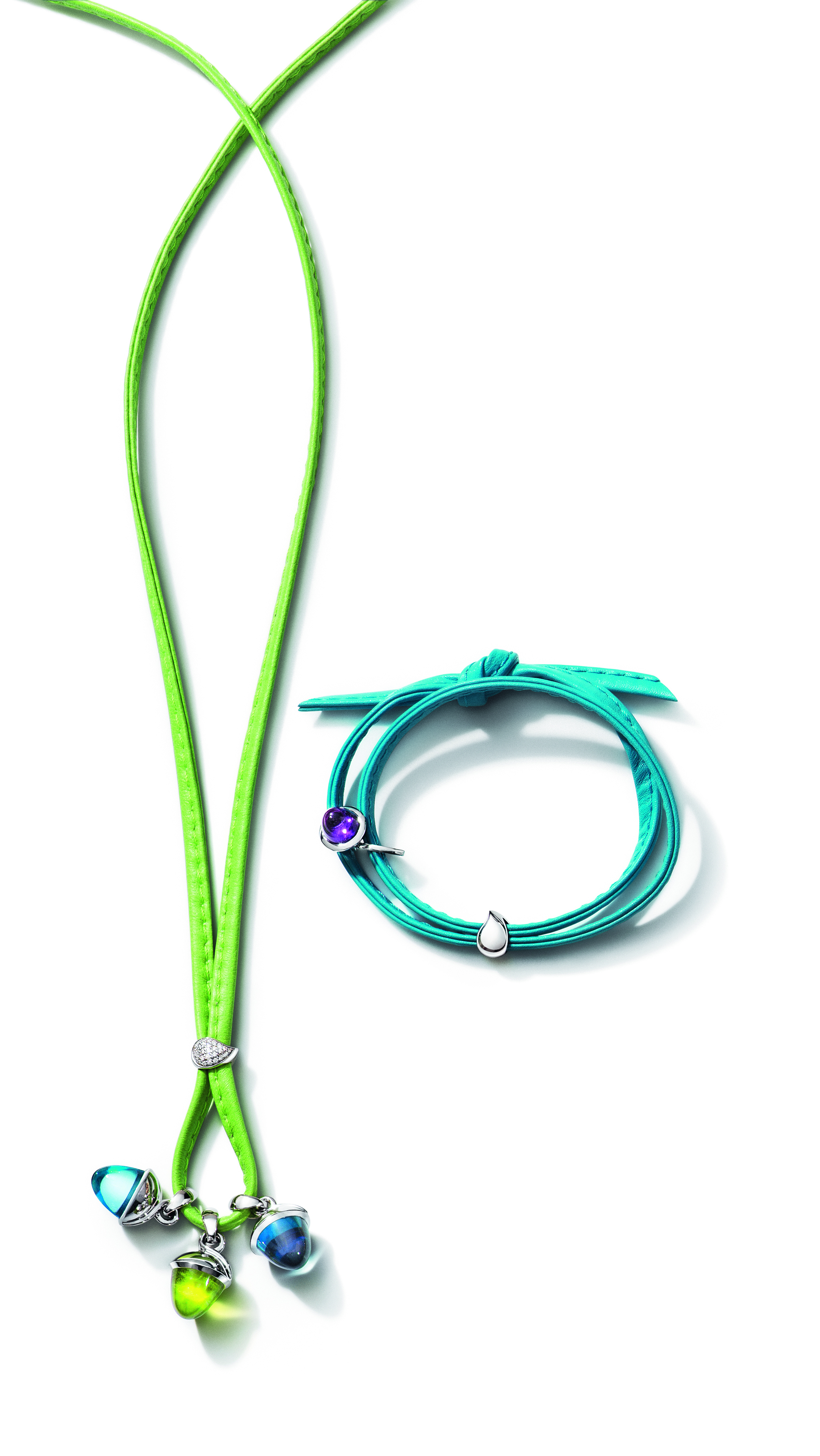 A green leather necklace with three colorful charms and a turquoise leather bracelet with a purple gem and silver teardrop charm.