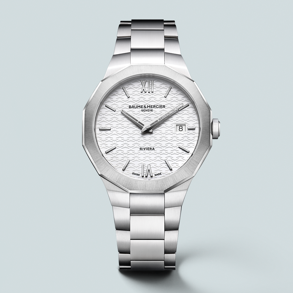 A silver Baume & Mercier Riviera watch with a white patterned dial and date window.