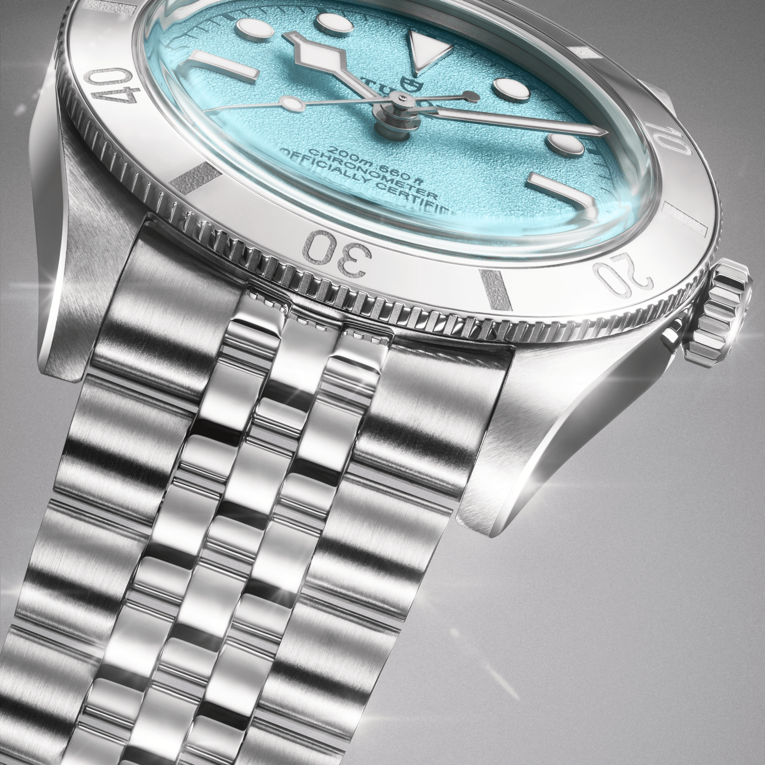A close-up of a silver watch with a light blue face and silver hands, on a silver bracelet.