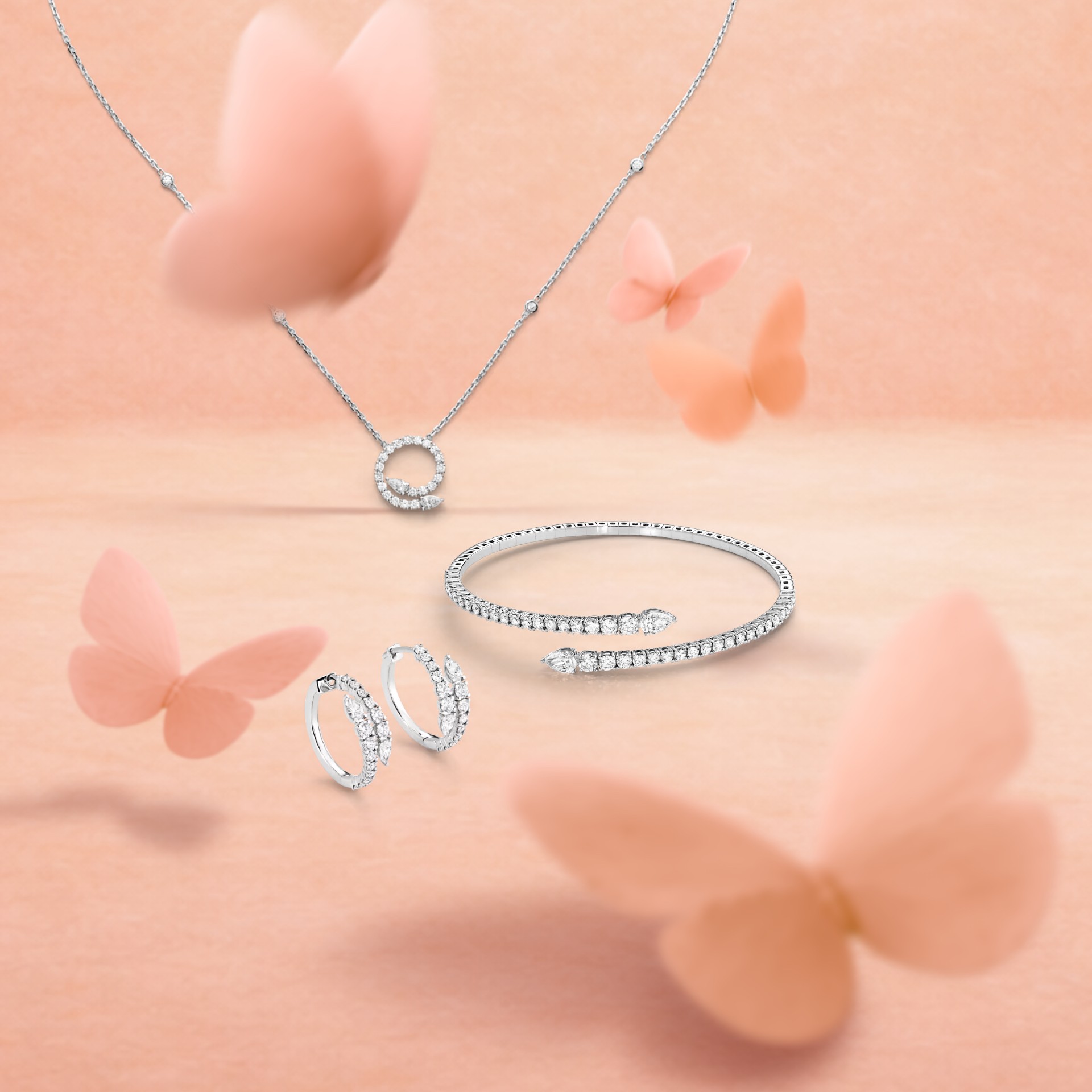 Eine Diamantkette mit kreisförmigem Anhänger, ein Diamantarmband und Diamant-Creolen auf pfirsichfarbenem Hintergrund mit verschwommenen Schmetterlingen.