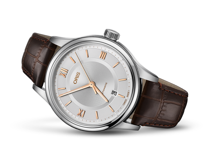 A silver Oris automatic watch with a white face, rose gold hands, Roman numerals, and a brown leather strap.