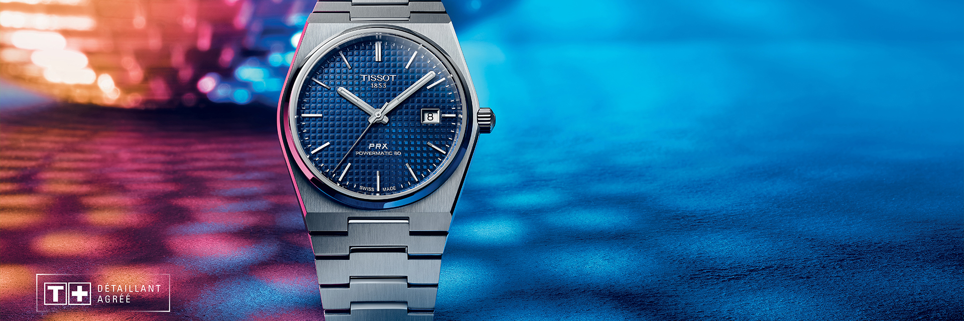 Banner showcasing the Tissot PRX watch with a textured blue dial and sleek stainless steel bracelet, set against a vibrant background with blue and pink lighting effects. The watch captures a modern yet classic style, highlighting Tissot’s dedication to precision and design.