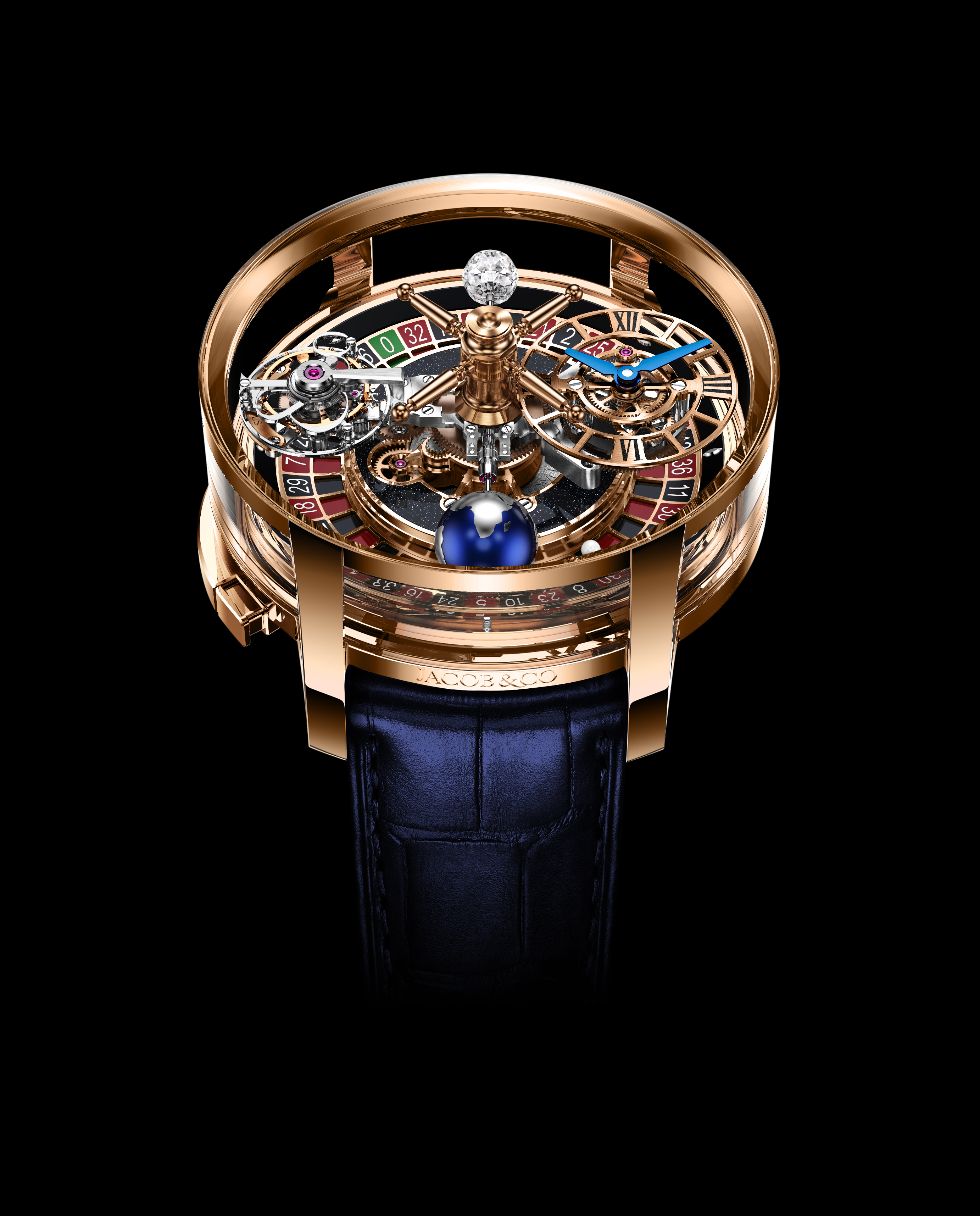 A rose gold watch with a roulette wheel, a diamond, and a blue globe on its face, on a dark blue leather strap.