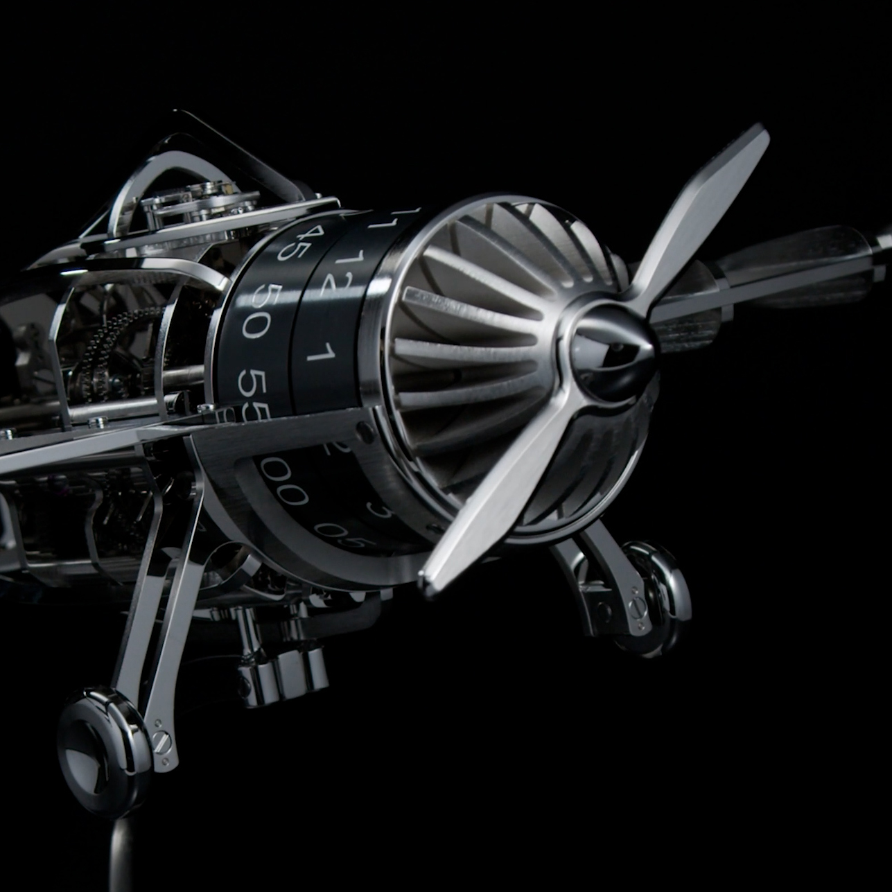 A chrome-plated mechanical airplane model with a propeller, exposed gears, and numbered time-telling rings.