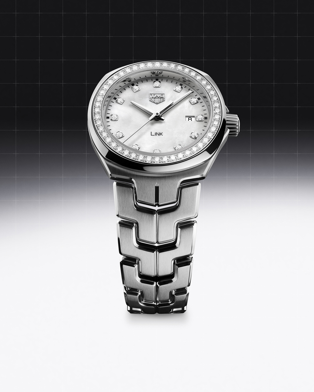 A silver Tag Heuer Link watch with a diamond-encrusted bezel and mother-of-pearl dial.