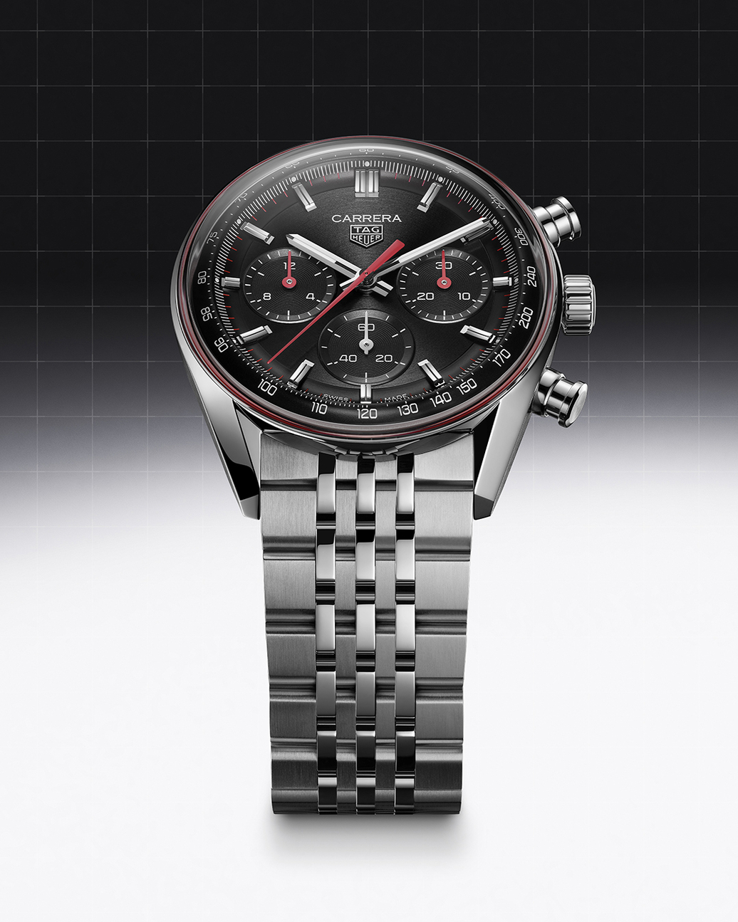 A silver Tag Heuer Carrera chronograph watch with a black dial, red accents, and a metal bracelet.