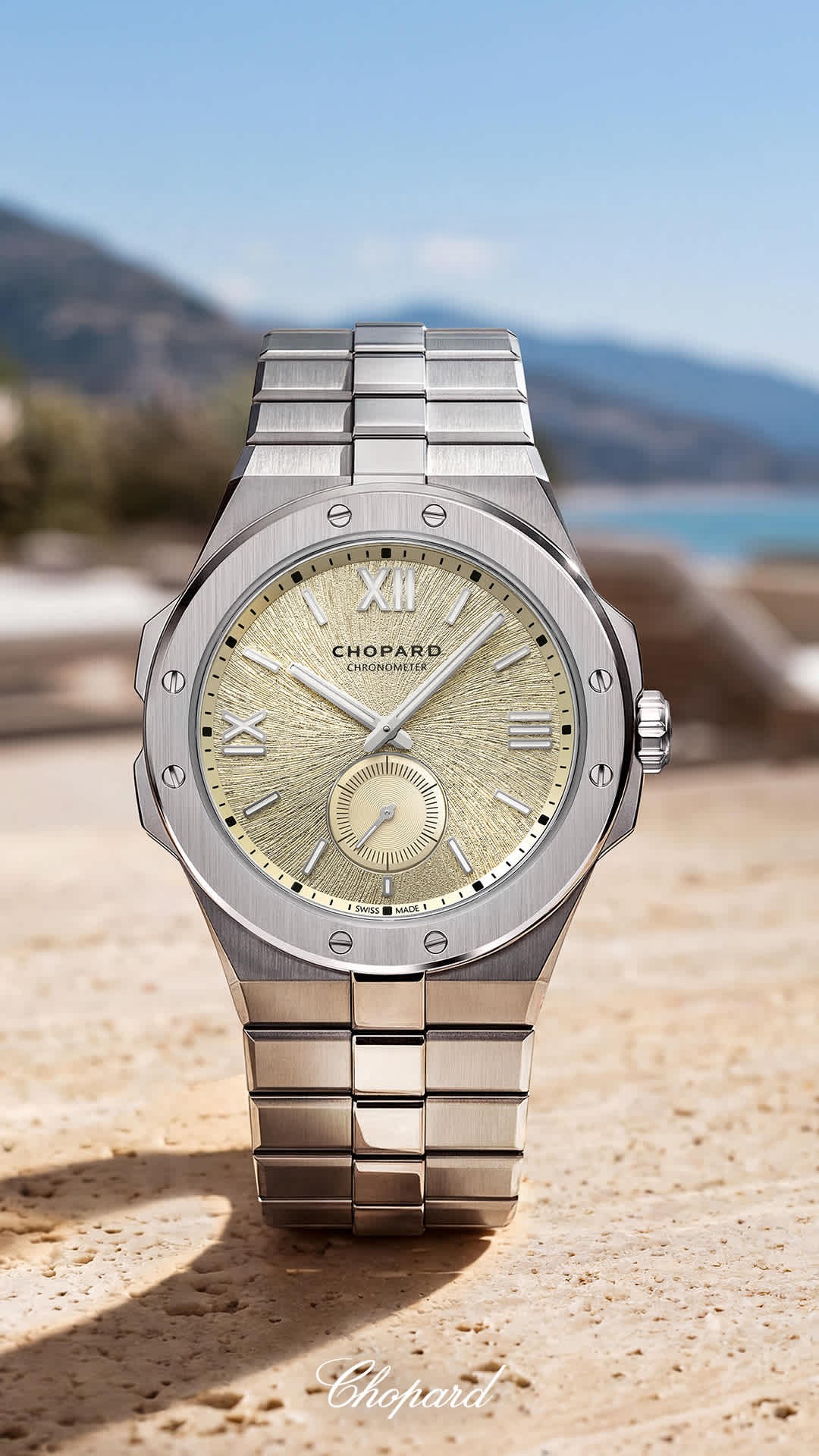 Chopard Alpine Eagle luxury steel watch with a textured golden dial and a matching metal bracelet.
