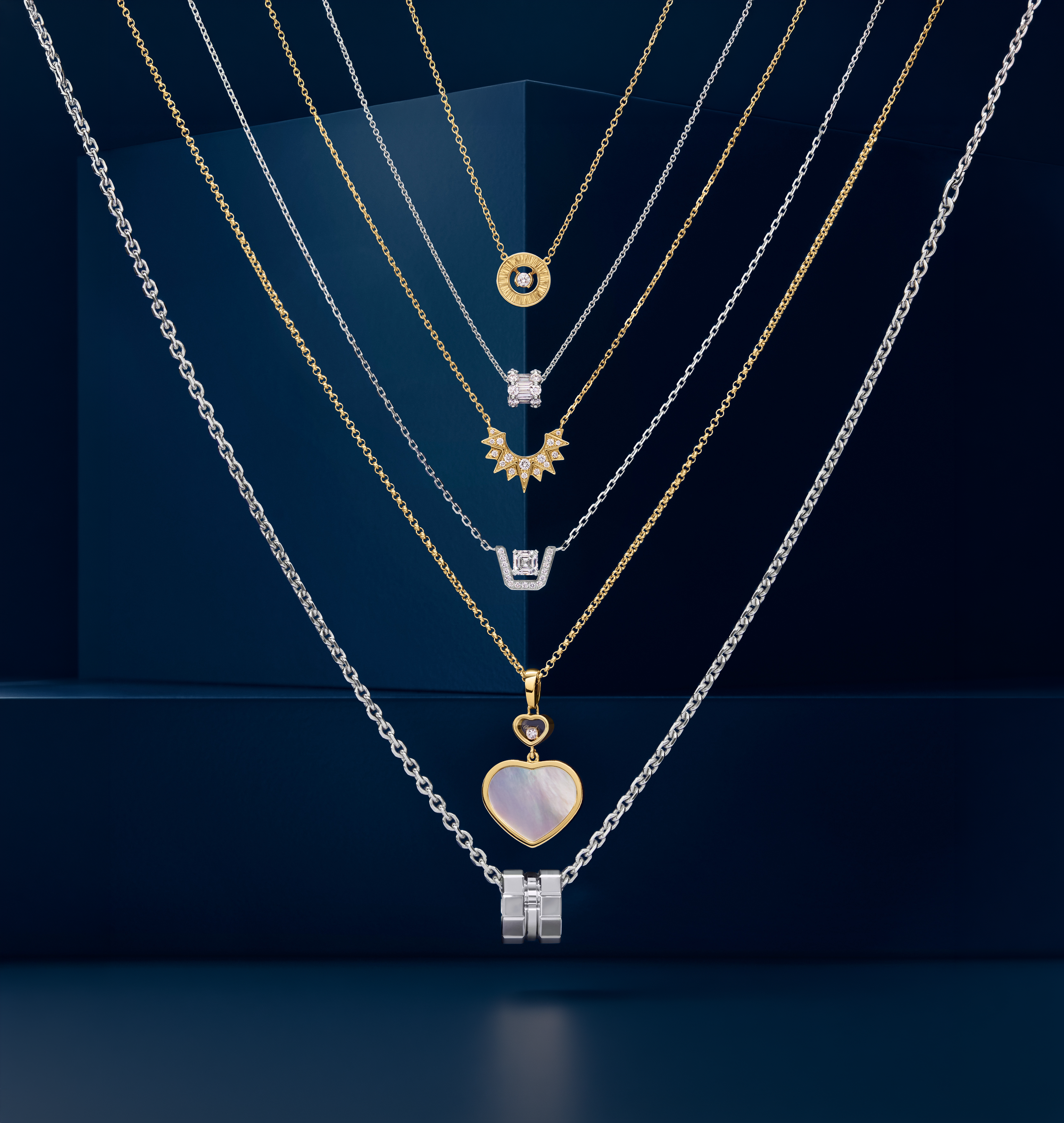Multiple layered silver and gold necklaces with various gemstone pendants displayed against a dark blue geometric background.