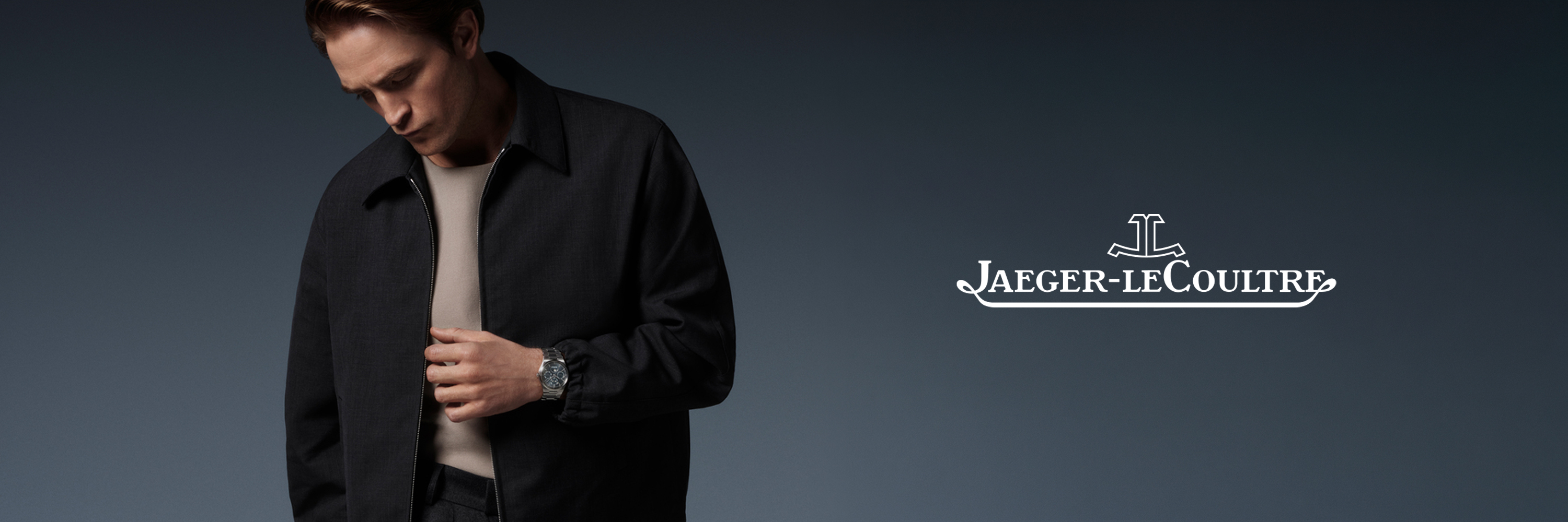 Ein Mann in einer schwarzen Jacke blickt auf seine Armbanduhr neben dem Jaeger-LeCoultre-Logo.