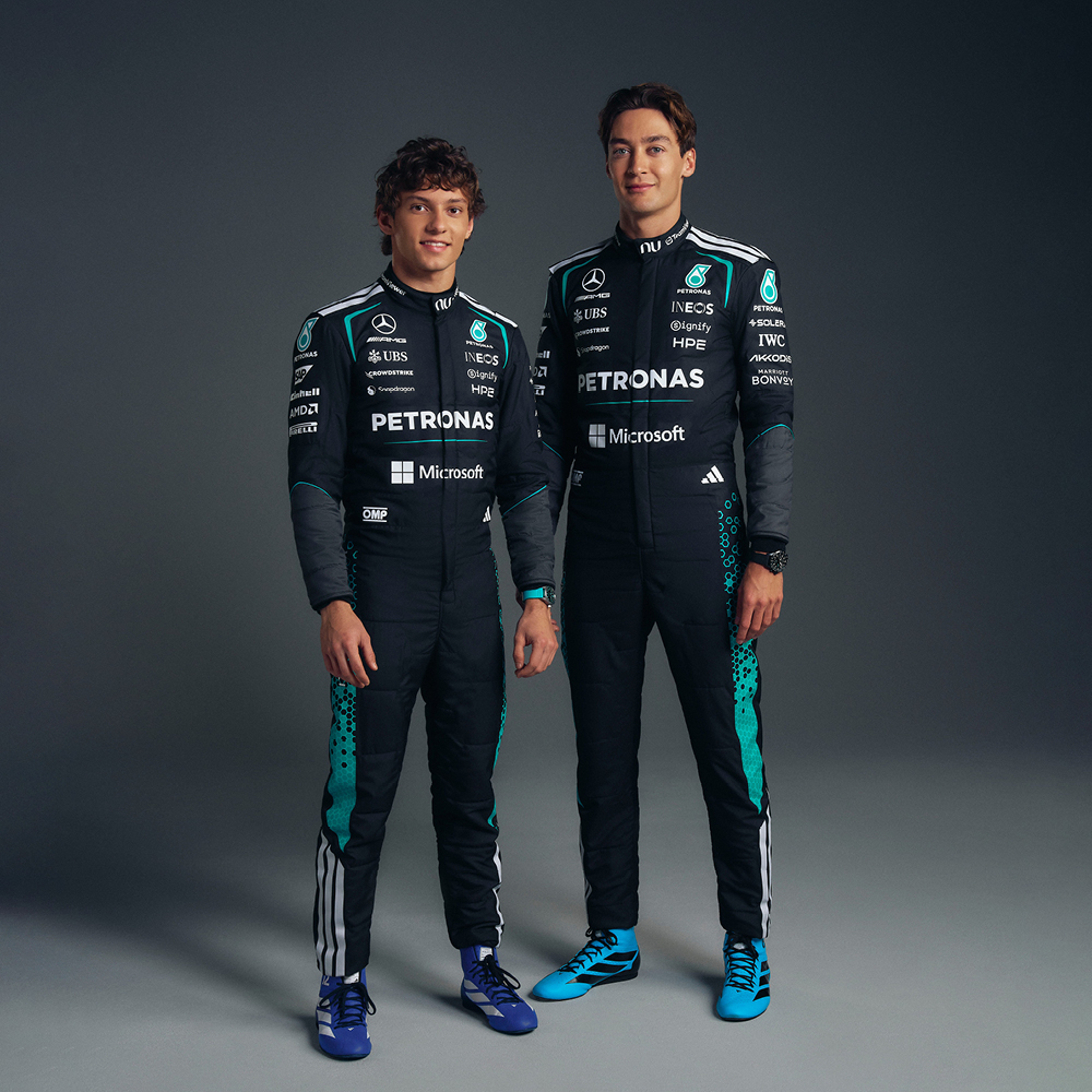 Formula One drivers Kimi Antonelli and George Russell stand side-by-side in matching Mercedes-AMG Petronas racing suits.