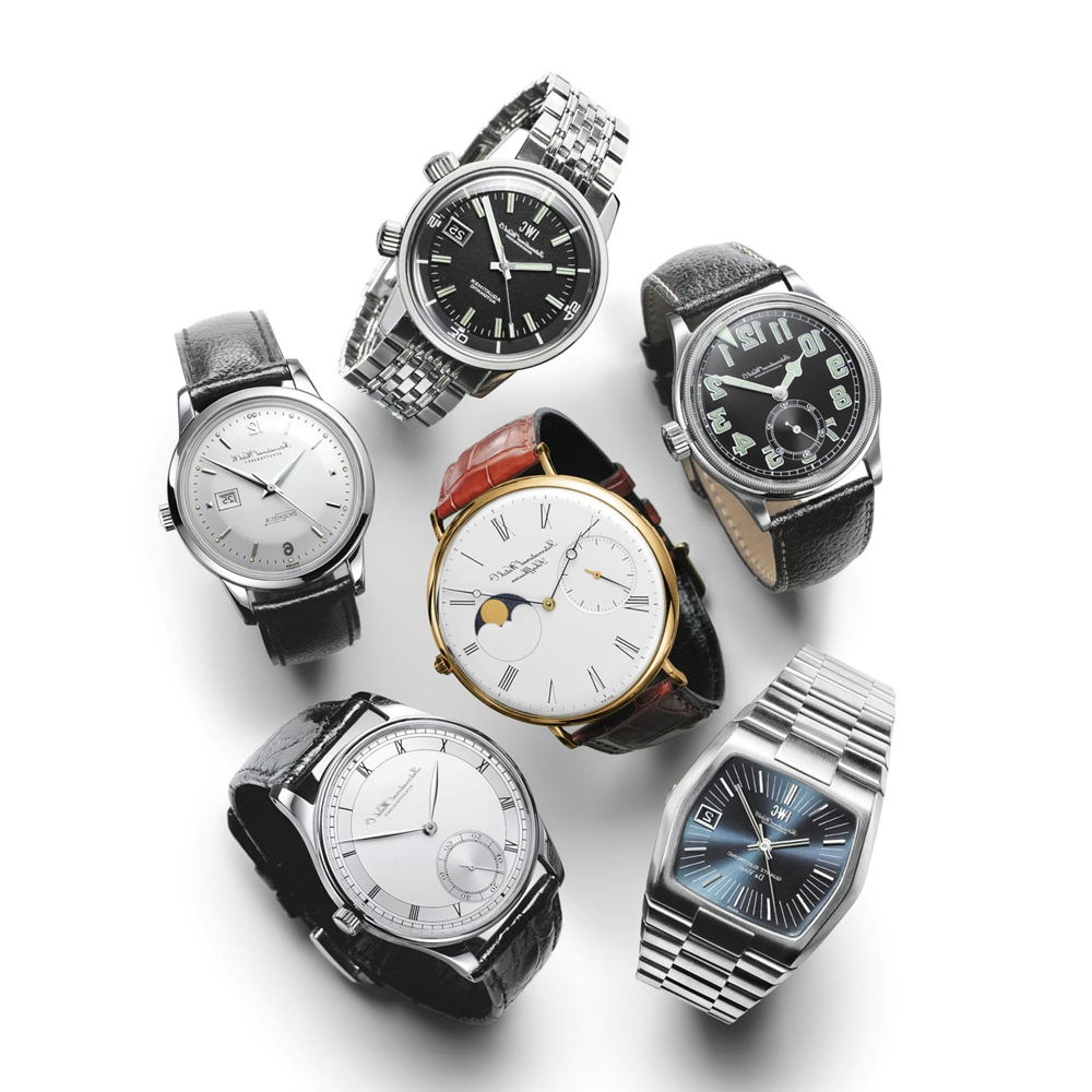 Six luxury wristwatches with various dials, straps, and bracelets are arranged on a white background.