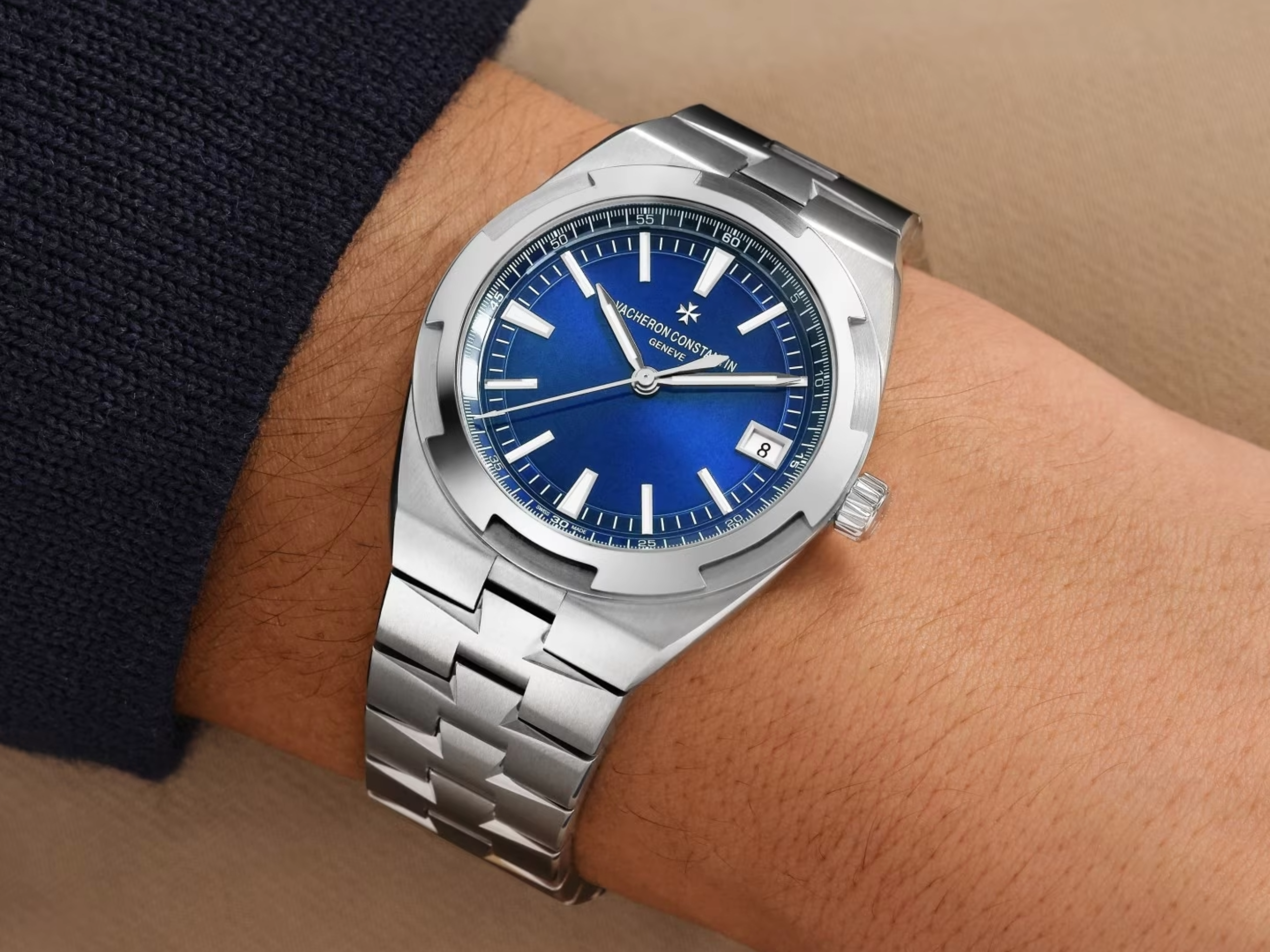 Eine Vacheron Constantin Armbanduhr aus Edelstahl mit einem leuchtend blauen Zifferblatt, die am Handgelenk getragen wird.